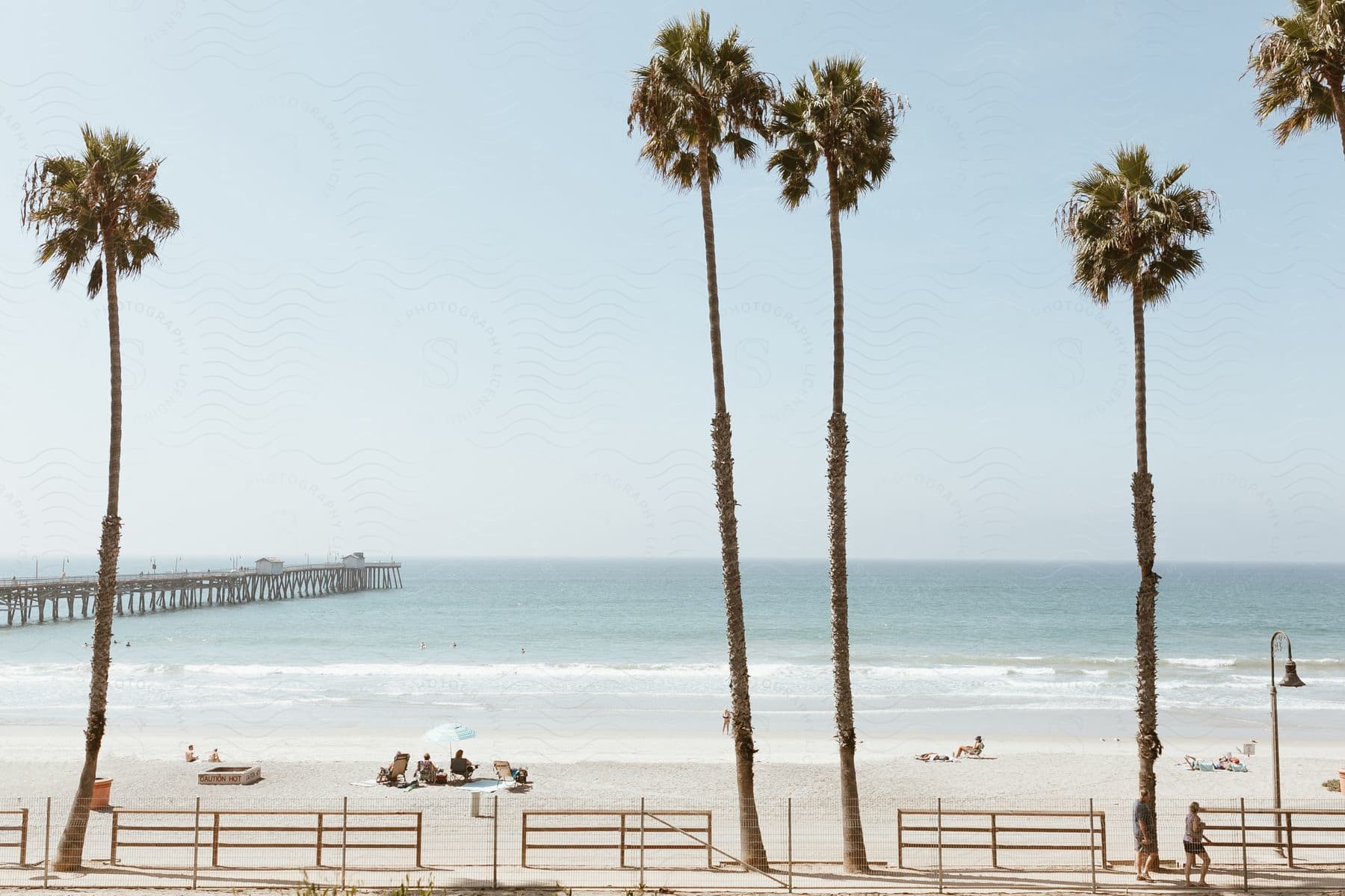 A serene beach scene with a boat on the water and palm trees in the background