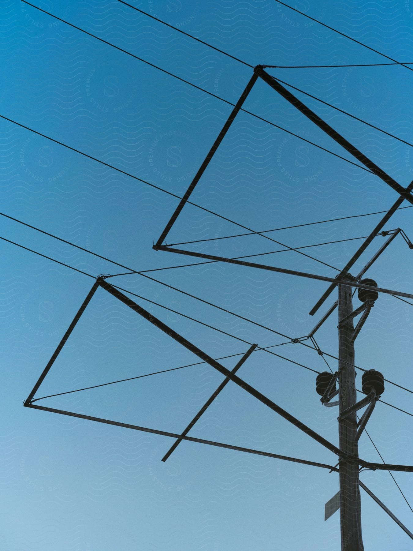 Angular frame connects to utility pole with multiple cables