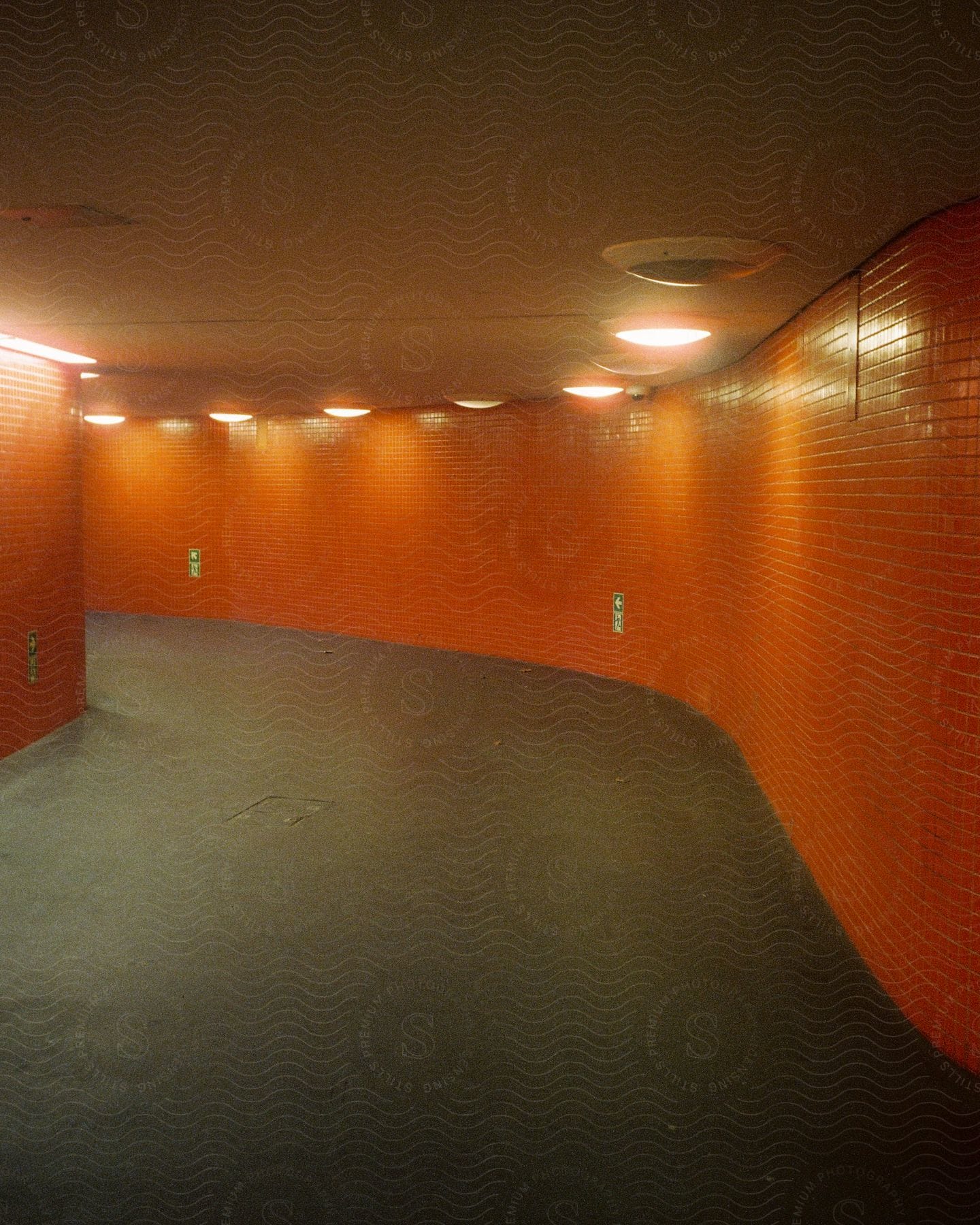 Corridor inside a building with black floor and red tiled walls
