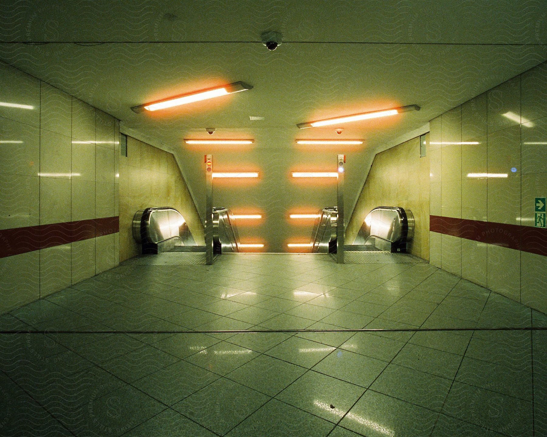 Bright orange lights reflecting on the floor and walls of a subway station in berlin