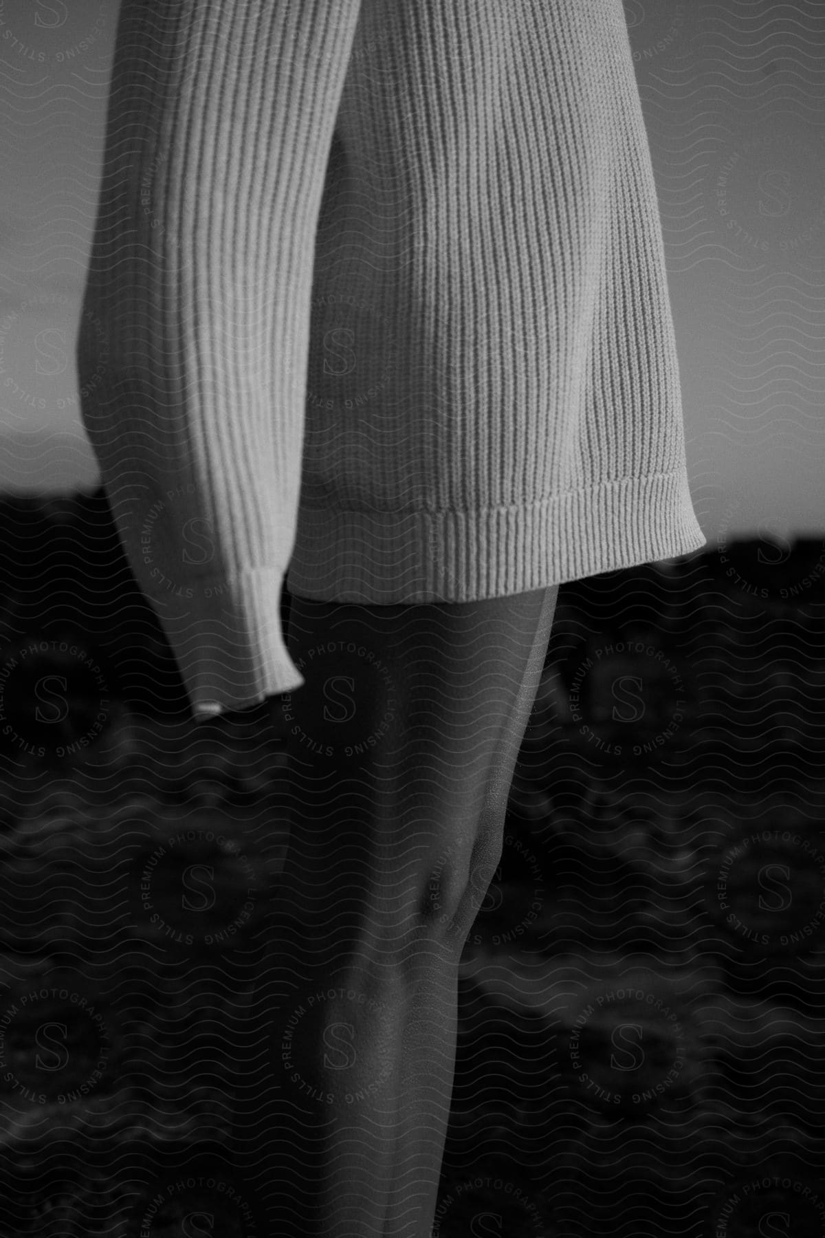 A person standing outside at night wearing a sweater without pants