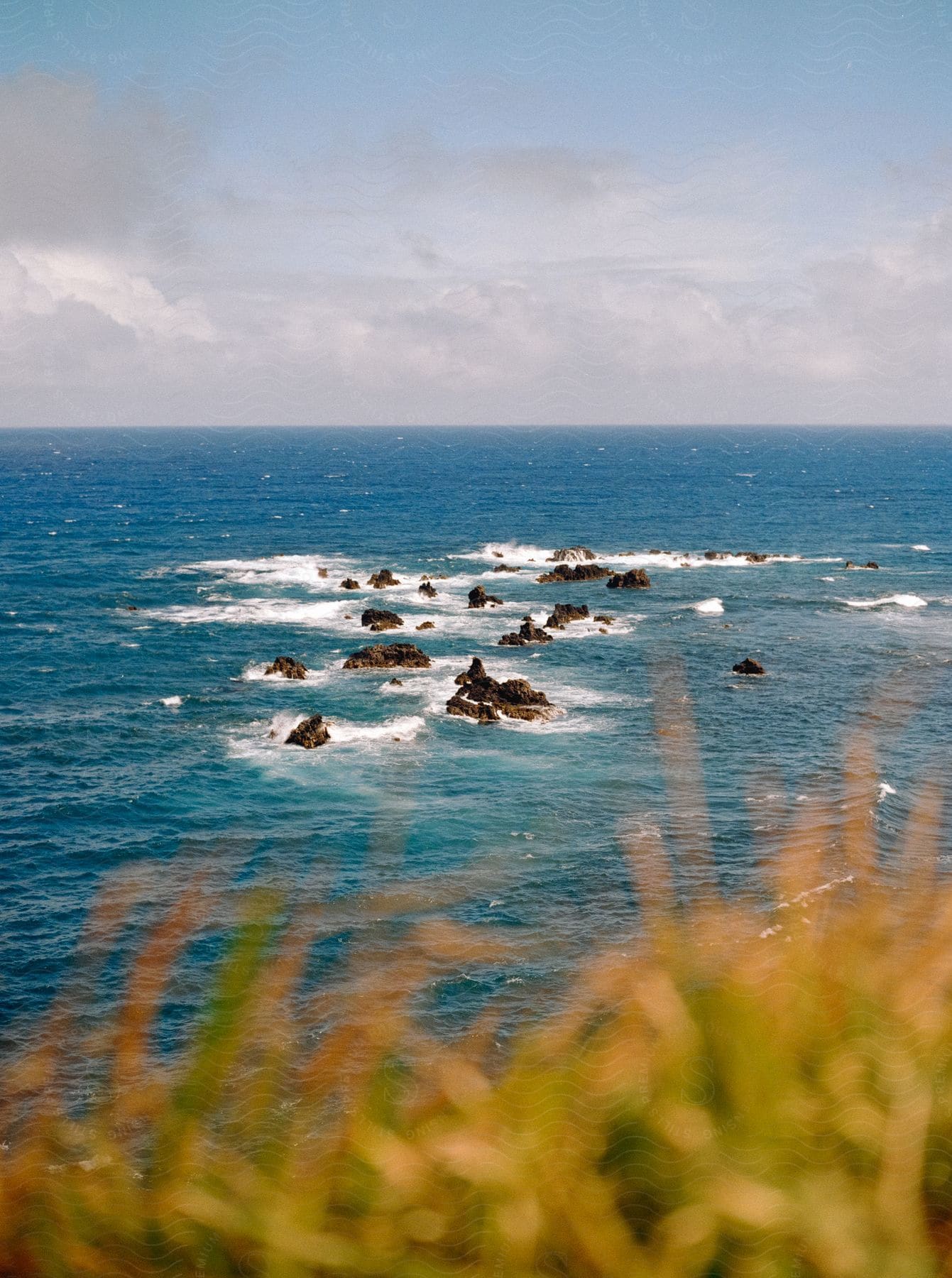 Rocks emerging from the sea along the coast on a sunny day