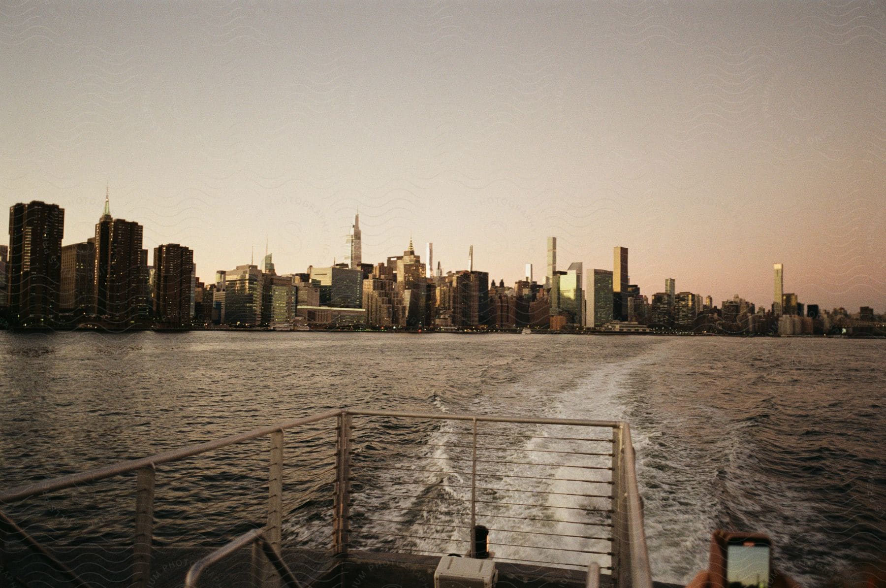 A boat moves through a city with tall buildings in the background