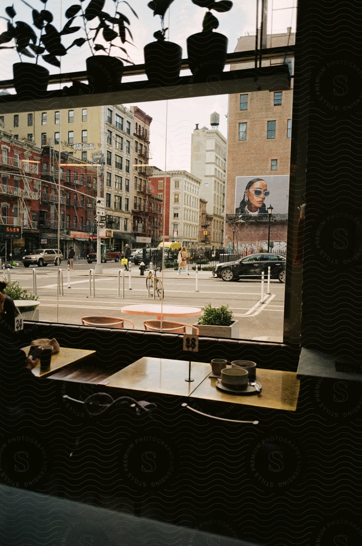 A person sitting at a coffee pot while reading a book indoors in new york city