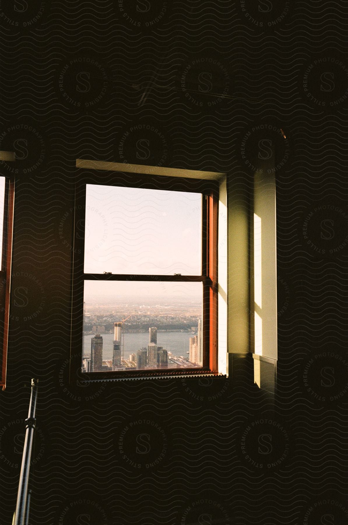 Light shines through a window framing a city skyline