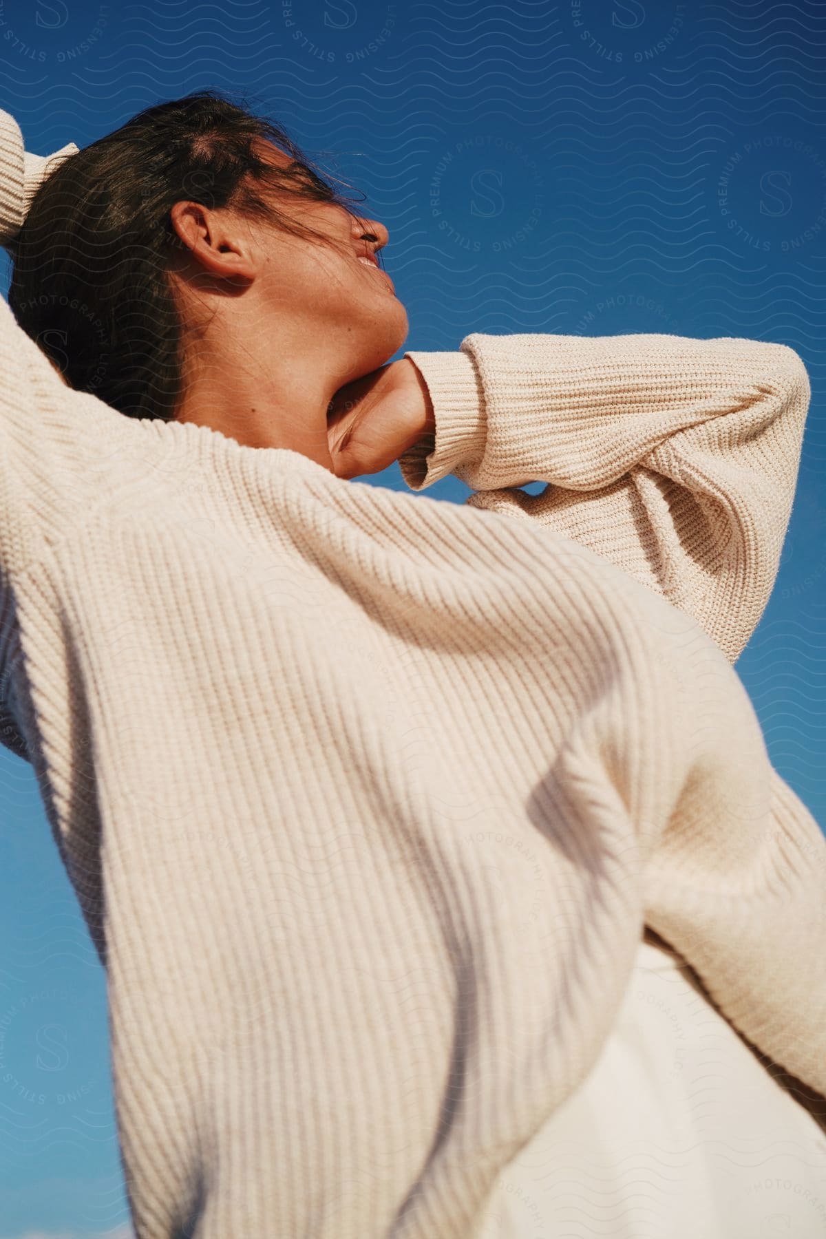 A woman models a cable knit sweater