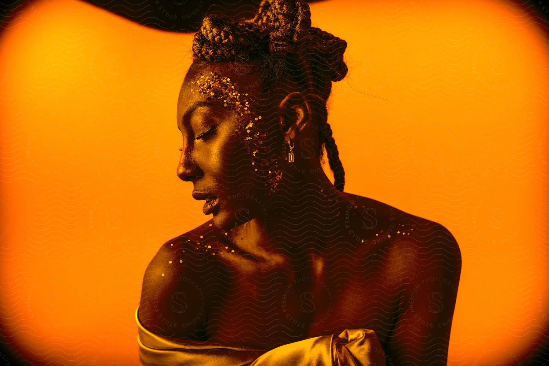 A woman poses in front of an orange background