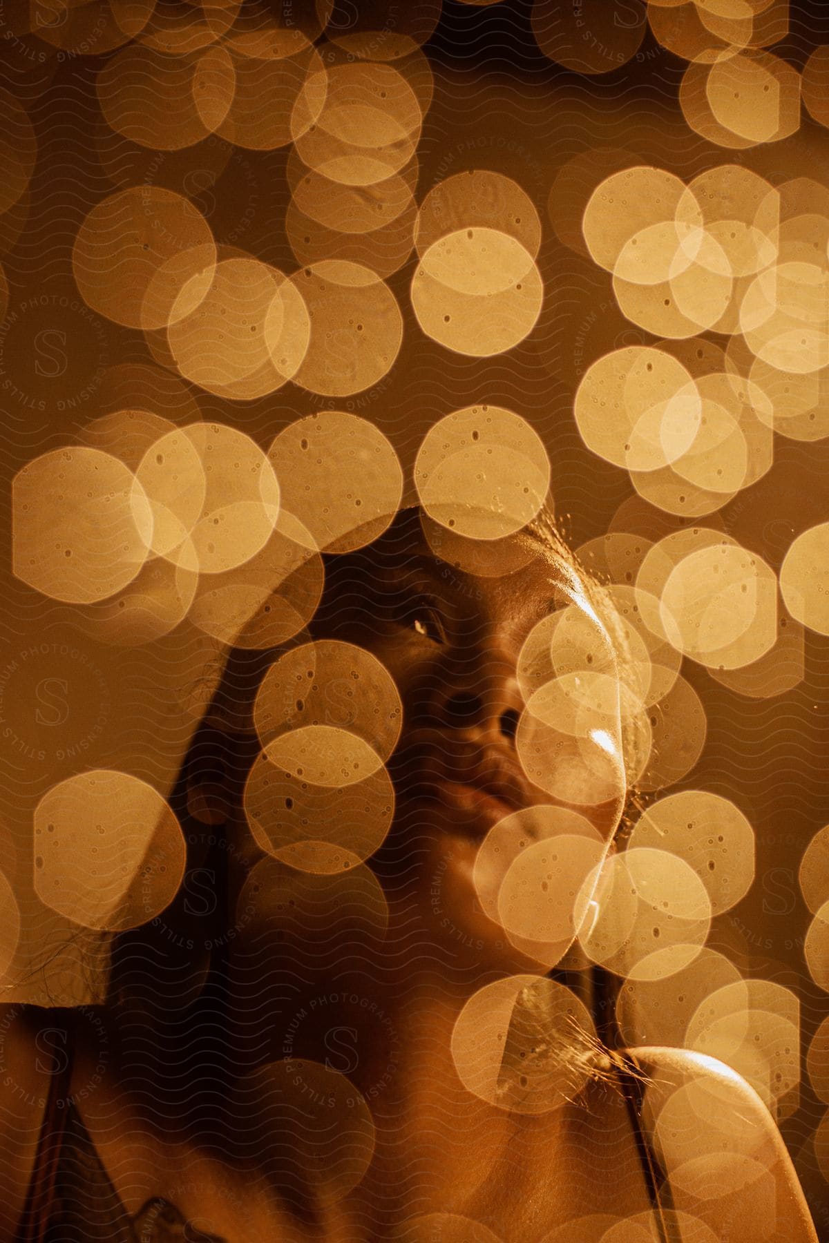 A woman covered in night lights gazes at the sky
