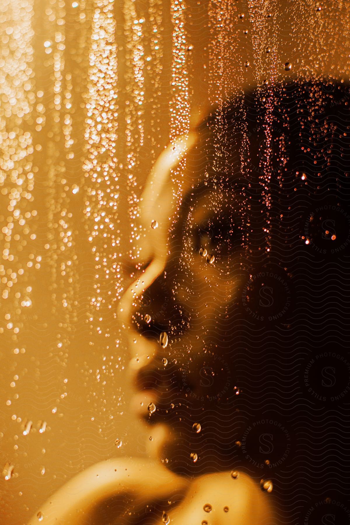 A person standing in a bathroom shower with water running