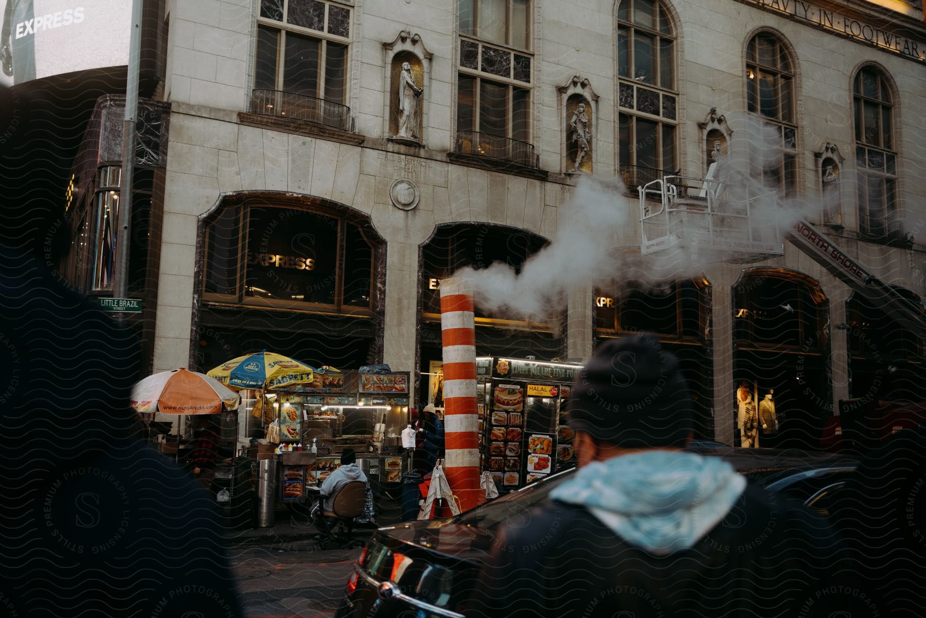 Building with old architecture with food stalls on the sidewalk in front of it