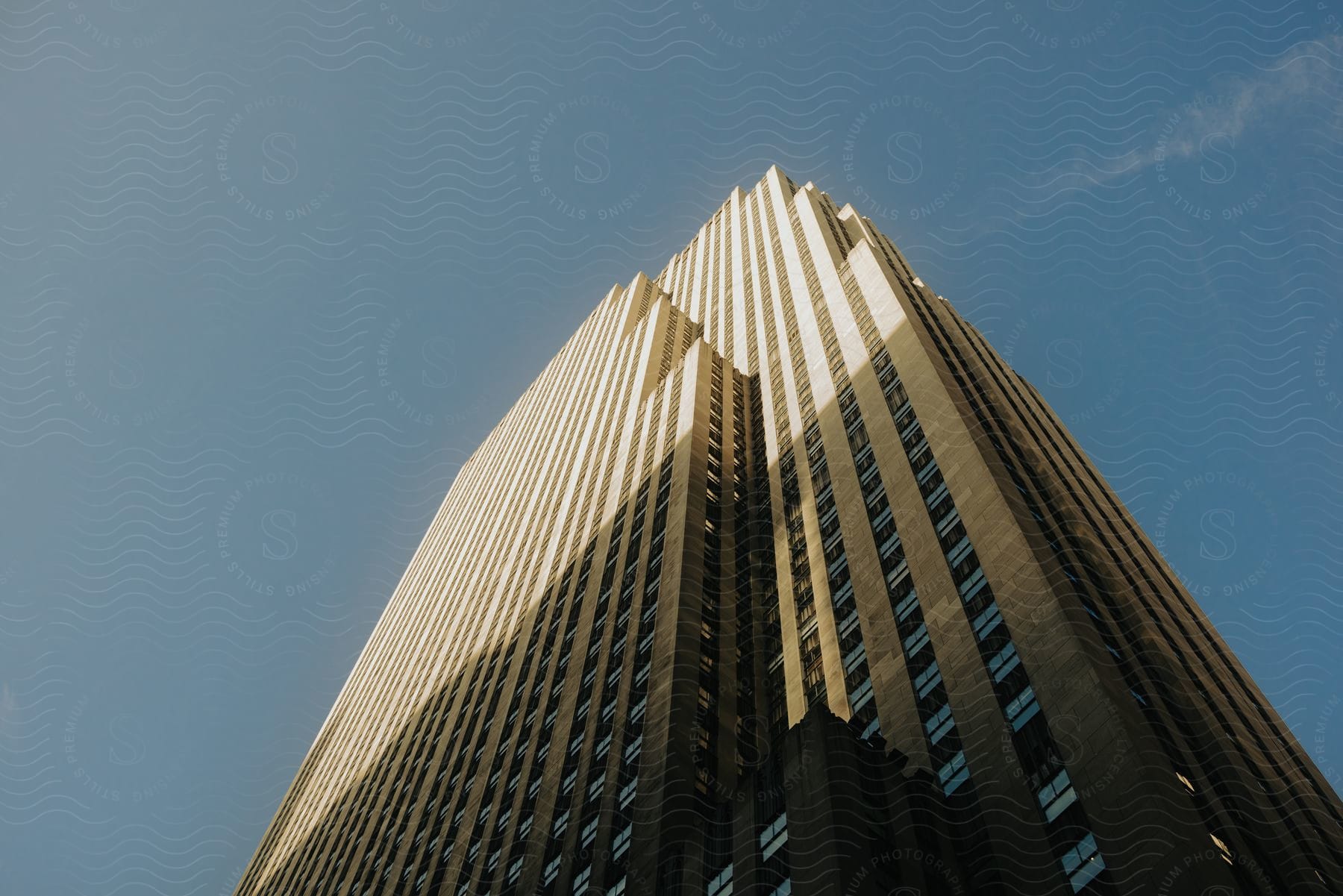 A Clear Blue Day With The Sun Illuminating Half Of A Skyscraper