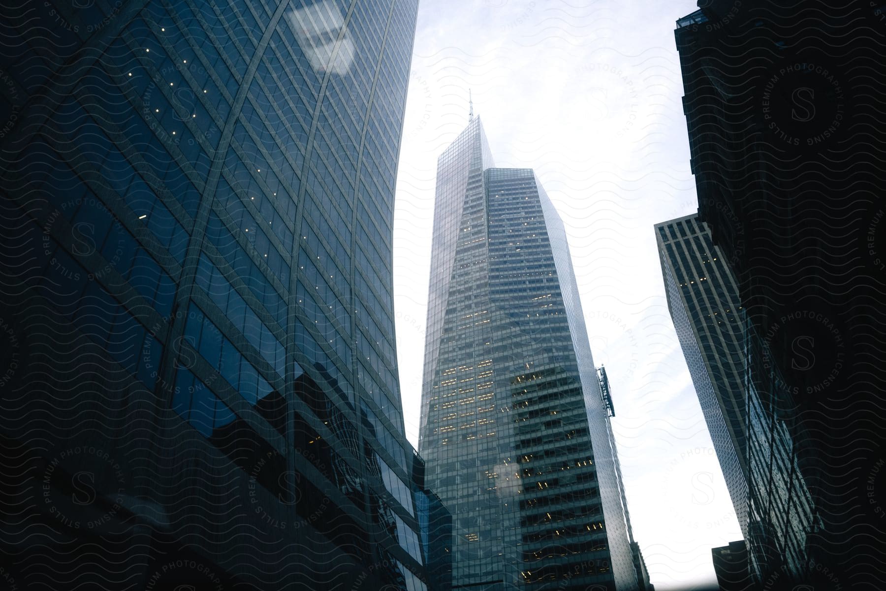 A skyscraper surrounded by other tall buildings on a cloudy day in new york city