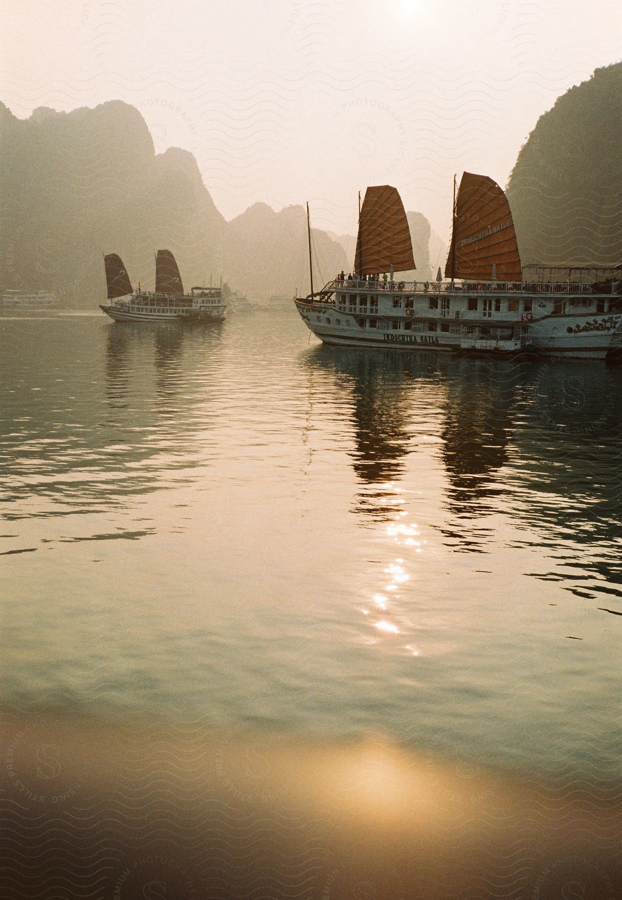 Two sailboats are heading toward the same river pass