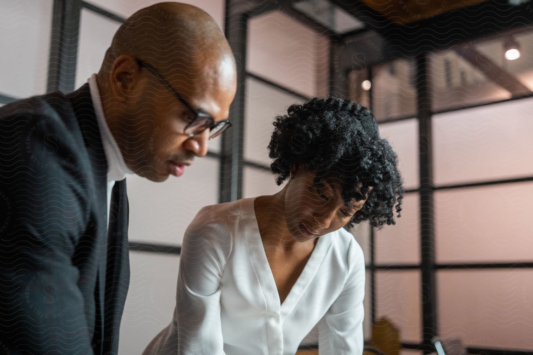 Businesswoman and businessman review designs in a meeting room