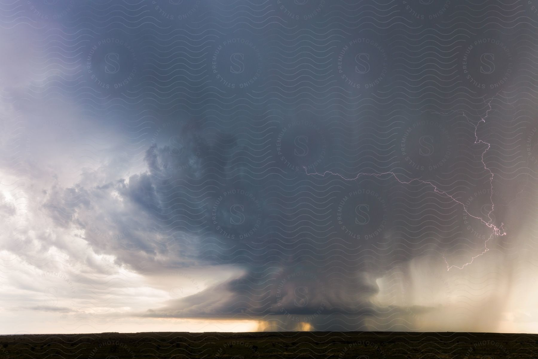 A large storm with thunder and wind is brewing on the horizon in the central plains of the united states