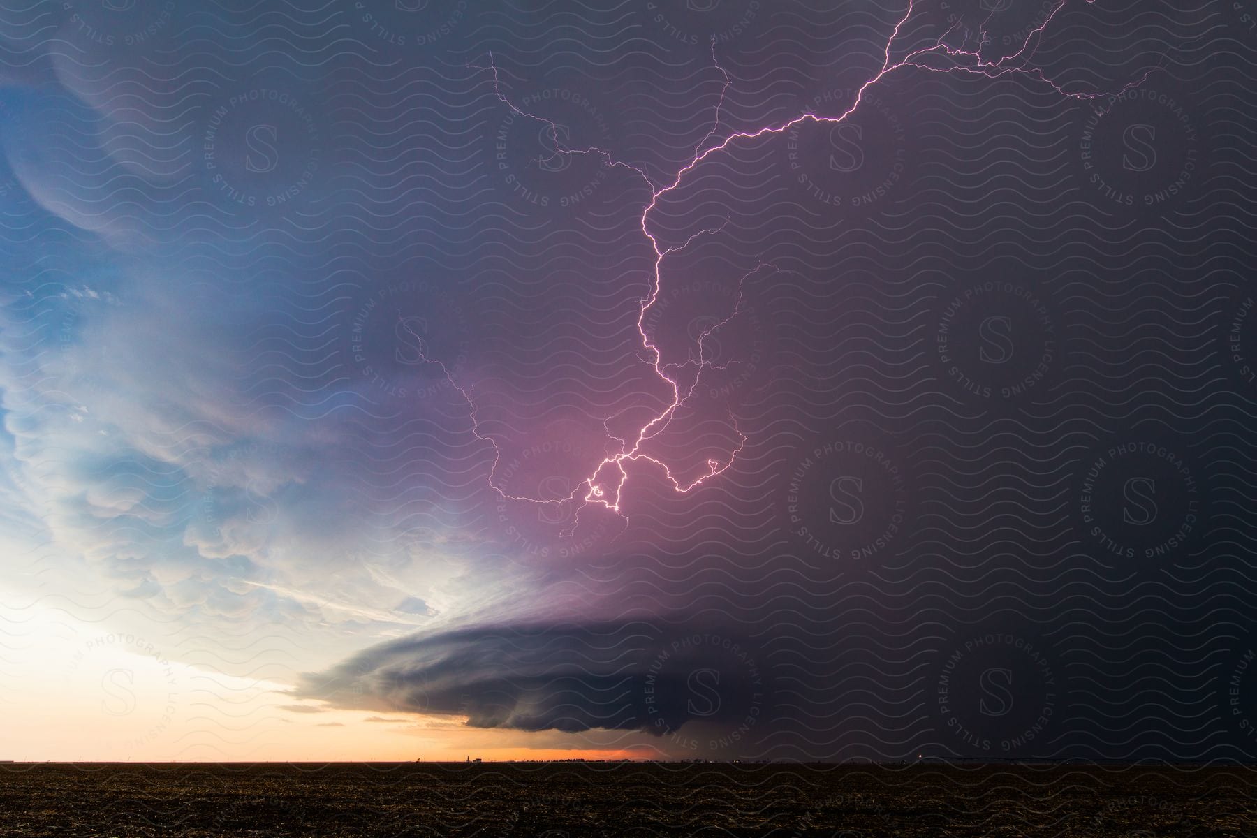 Purple lightning and rain falling from storm clouds over the plains