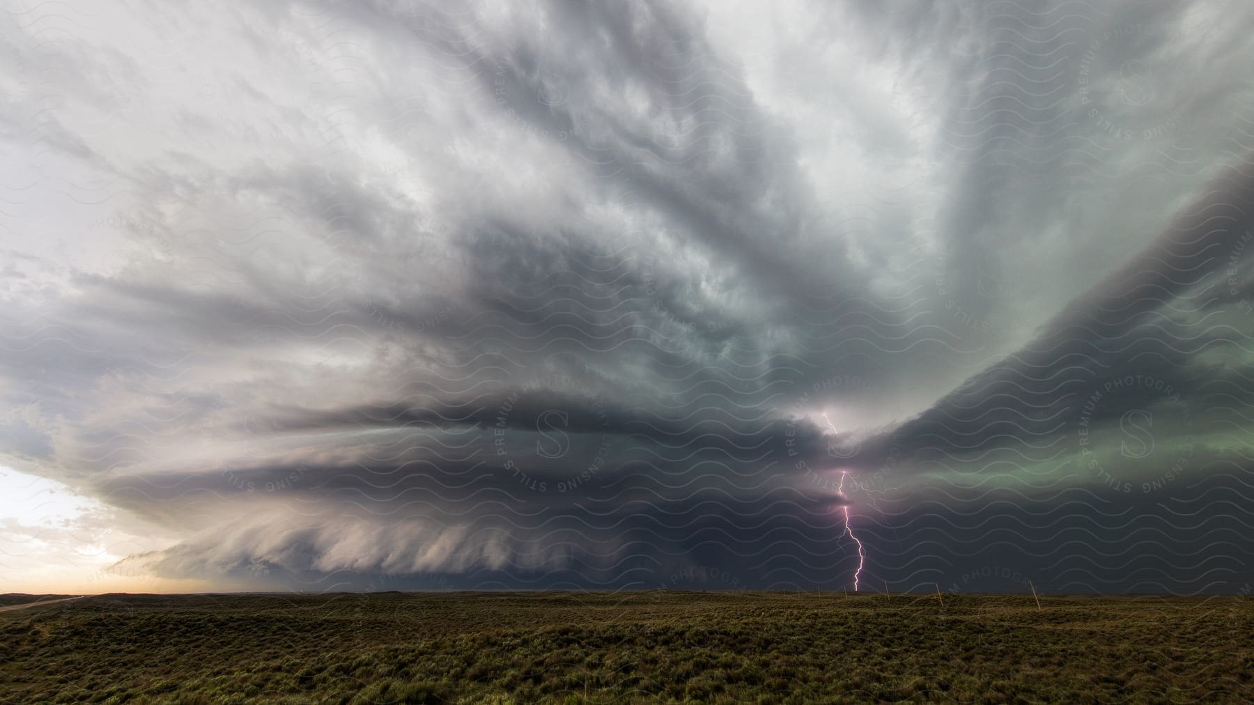 Lightning strikes from swirling clouds in the distance during a storm in kansas