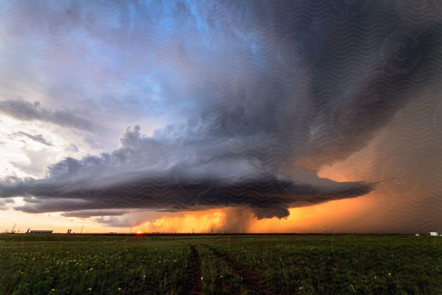 A supercell storm moves low over farmland at sunset in seminole texas