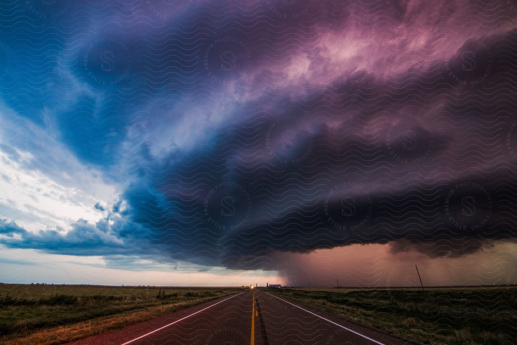 Highway stretches away while storm clouds gather in the sky