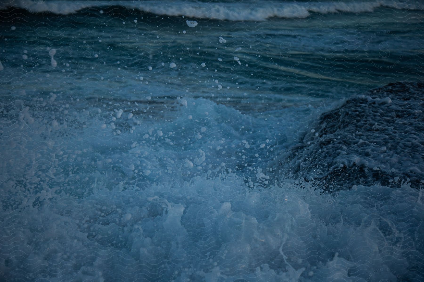 Foamy ocean wave moves across the surface of water