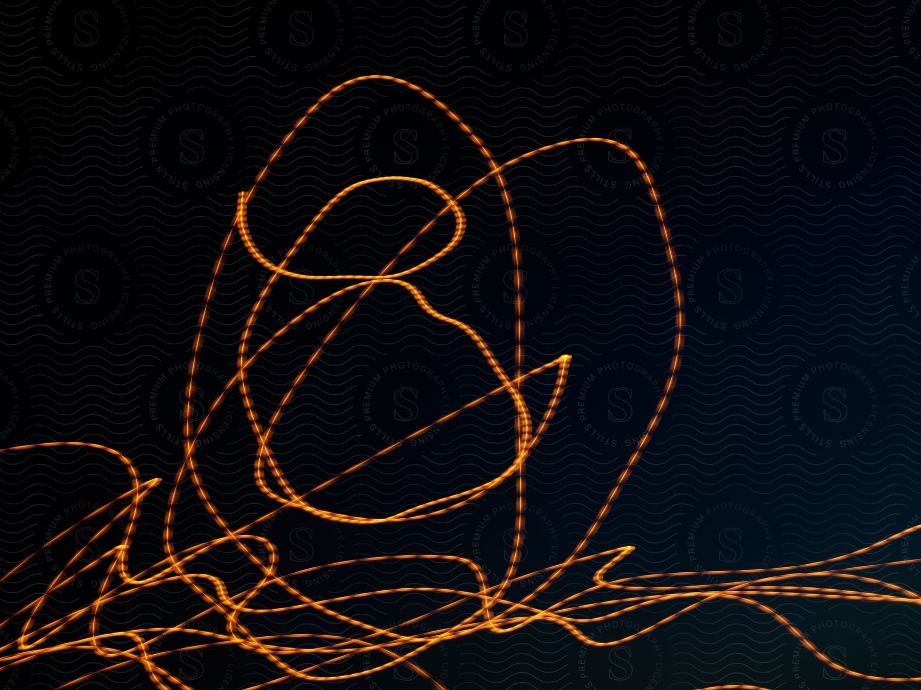 Stock photo of an abstract orange line encircles on a black screen