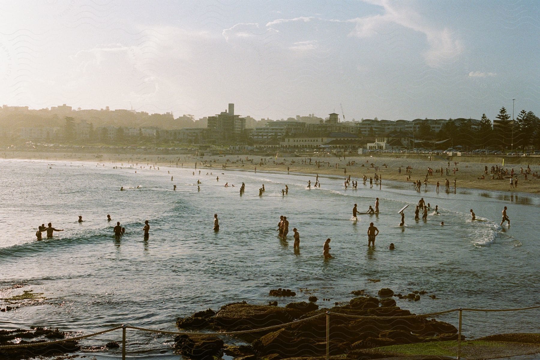 A crowd of people on a beach by the coastline