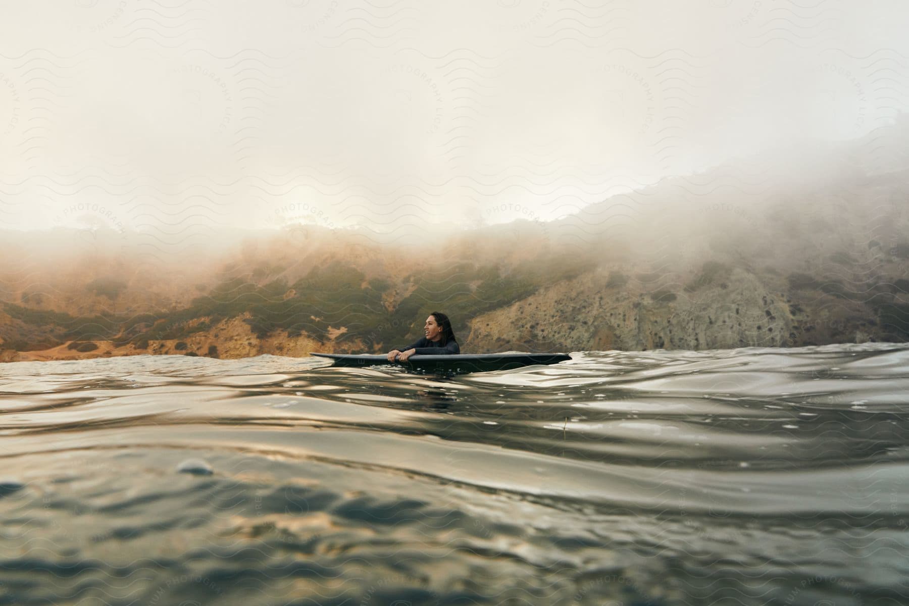 A person enjoying a water sport on a lake surrounded by mountains