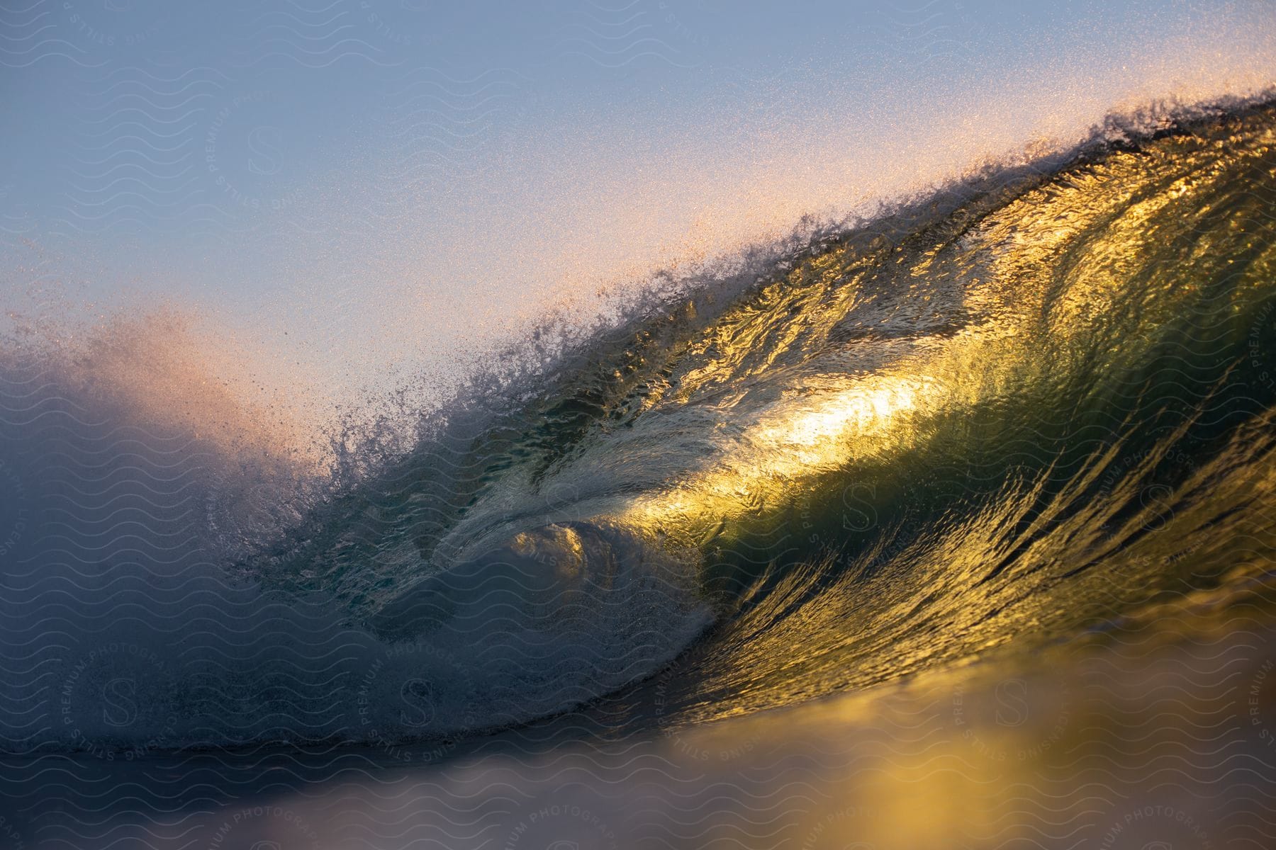 The sun shines through an ocean wave