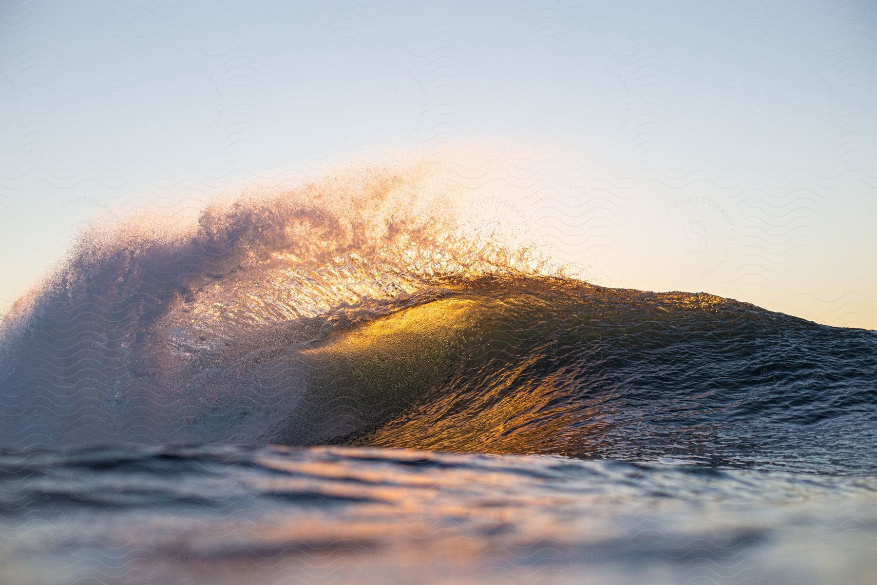 Sun shining through a moving ocean wave on the waters surface