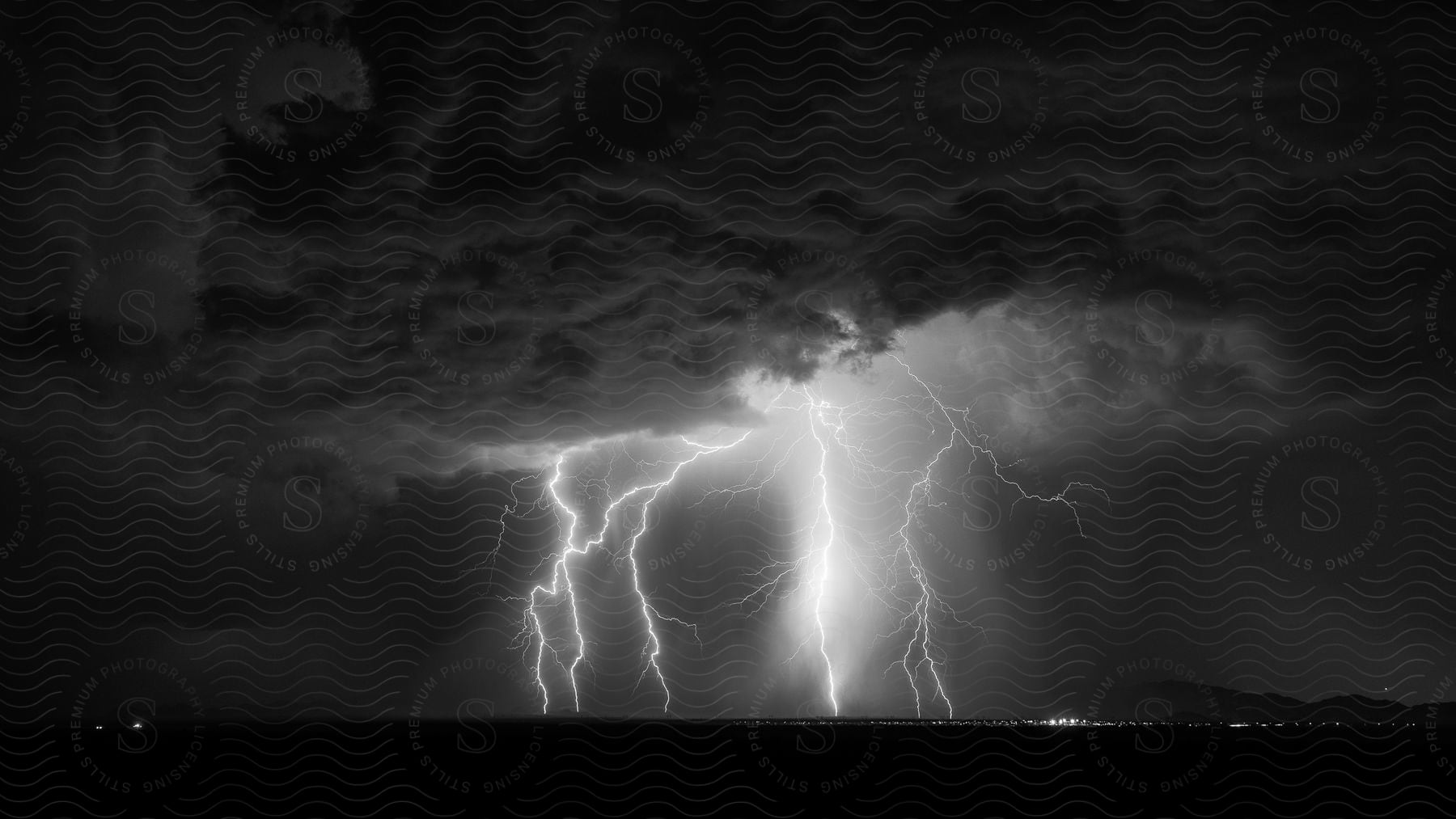 Lightning strikes the ground near a city at night