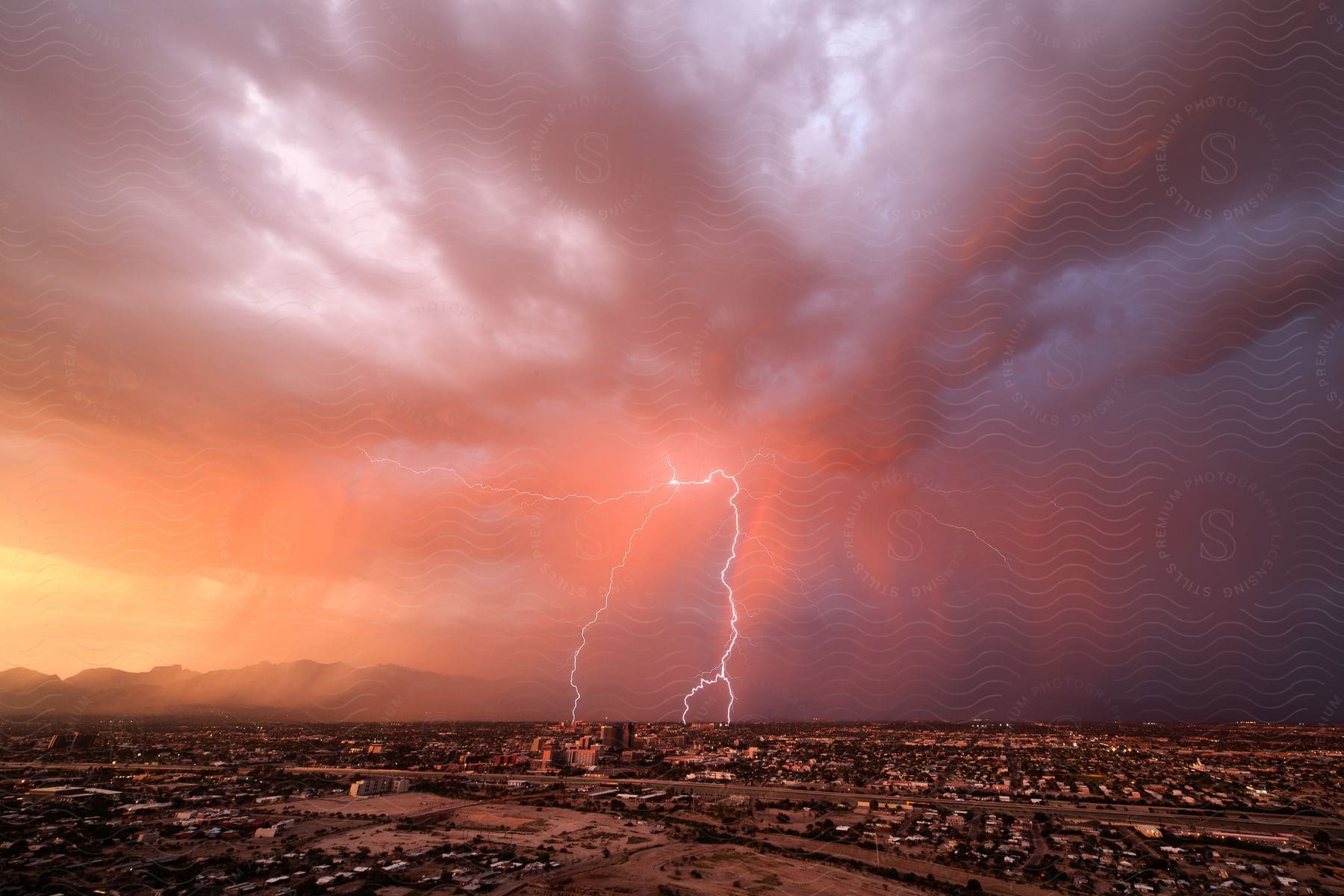 Heavy rainfall and lightning over a mediumsized city at sundown