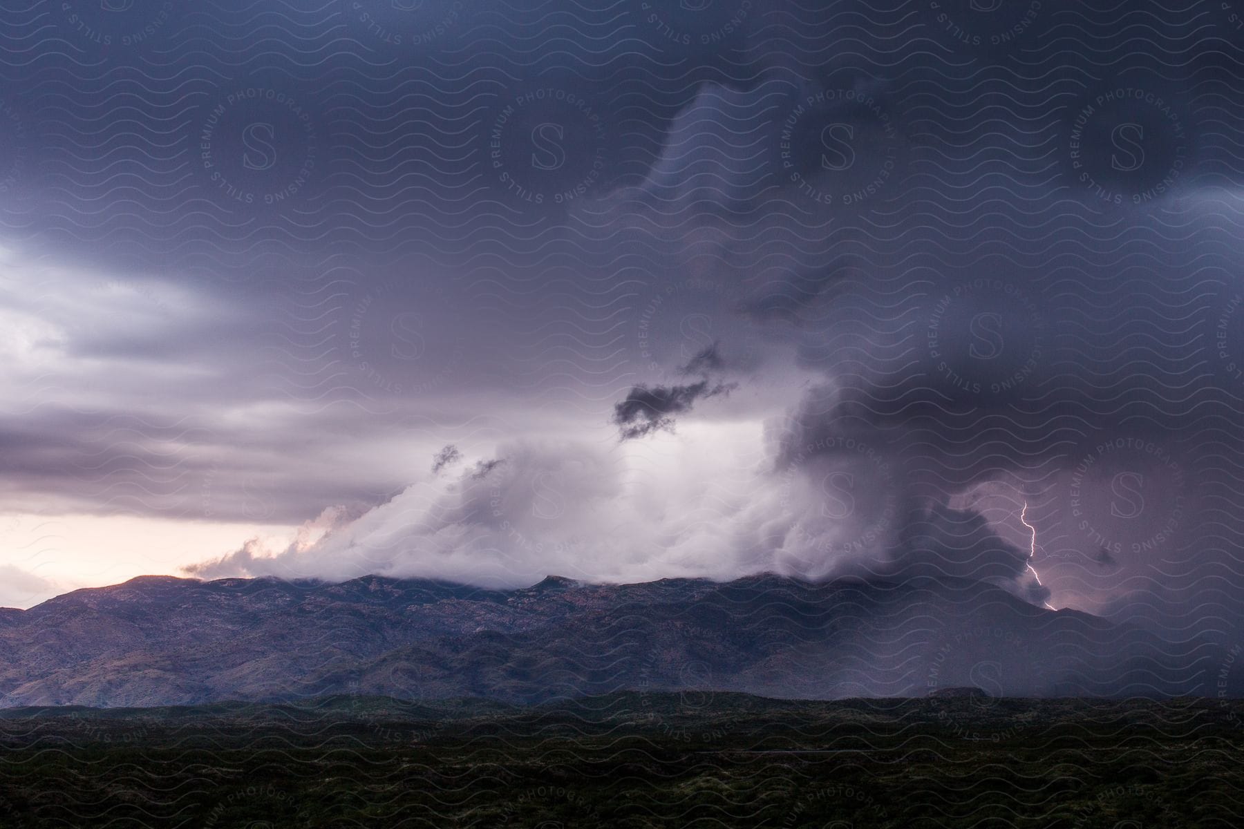 Thunderstorms gathering over a mountain at sunset