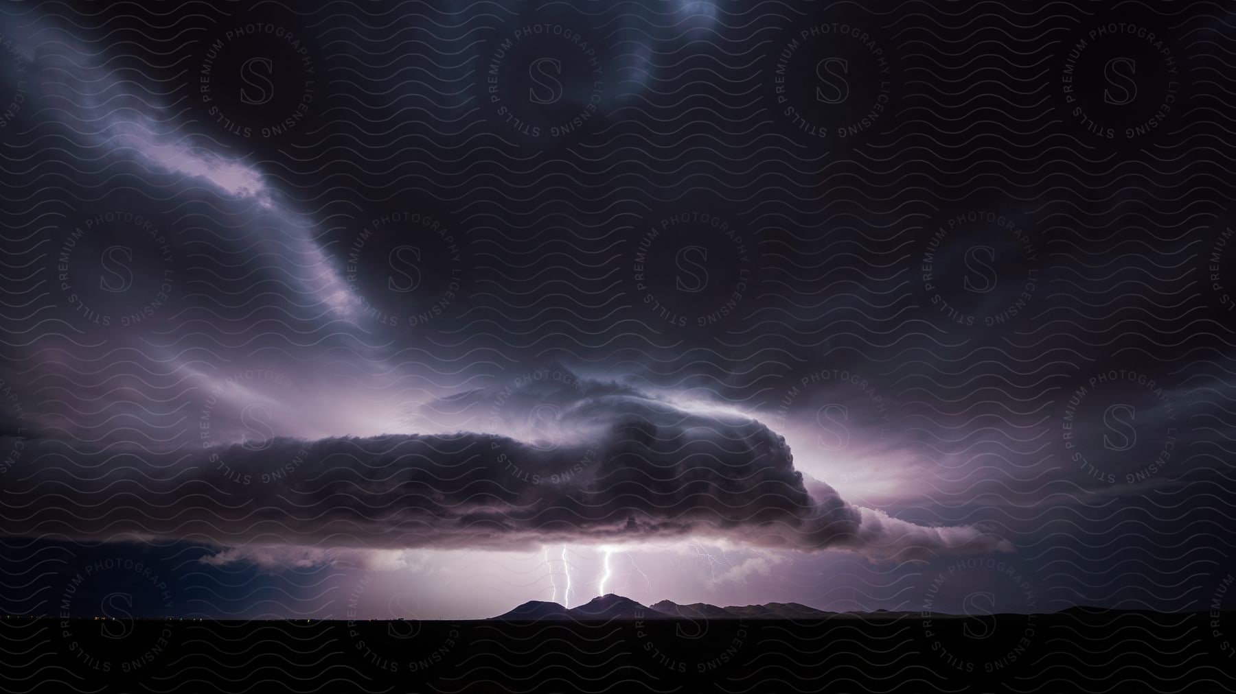 Lightning strike and dark storm clouds over the landscape during a thunderstorm