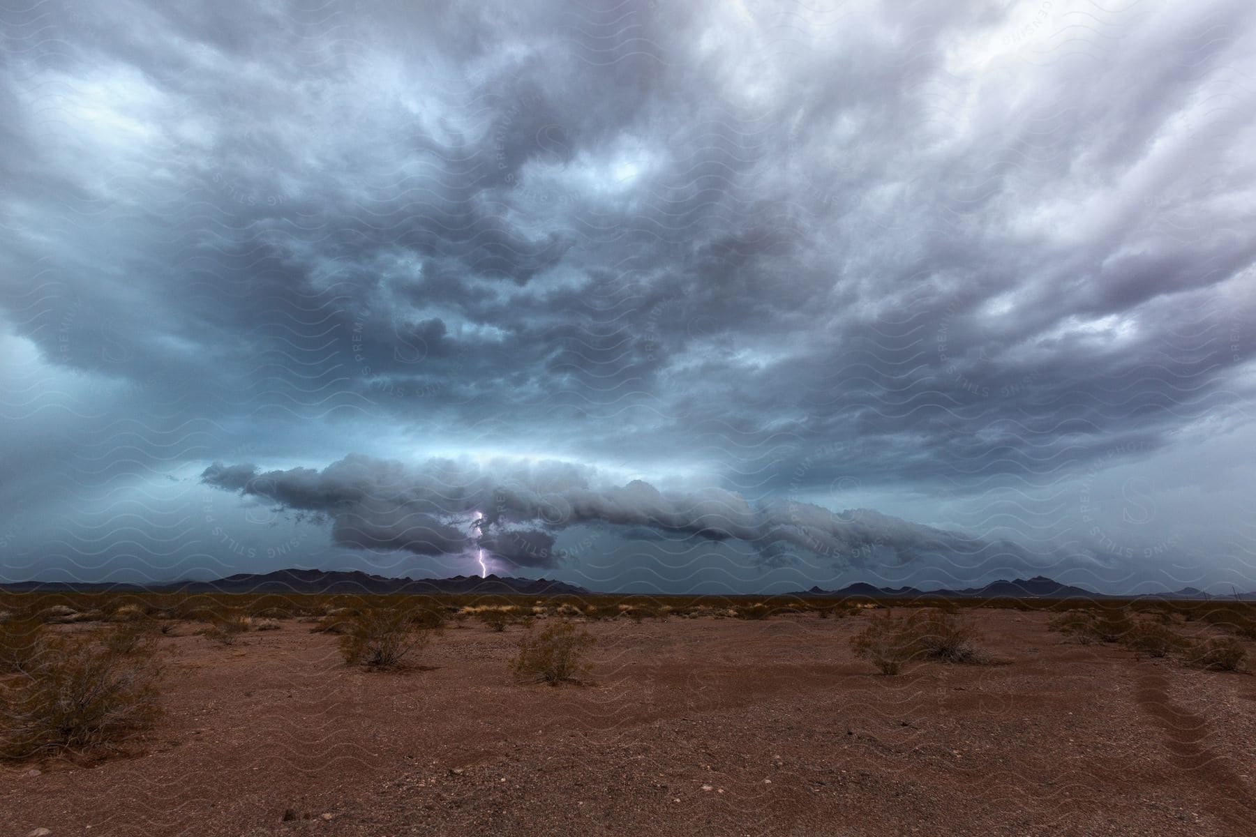 A lightning strike illuminates the sky during a thunderstorm over the trigo mountains in arizona