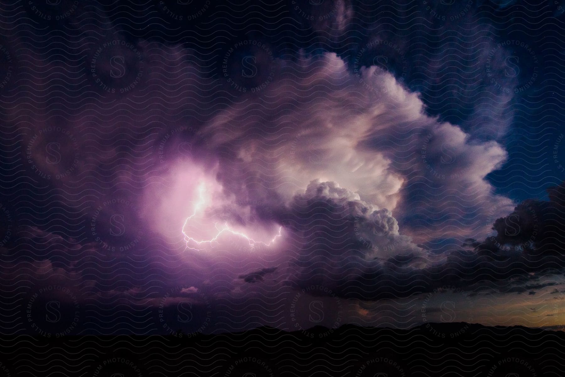 Purple lightning inside storm clouds over the plains during a southwest monsoon