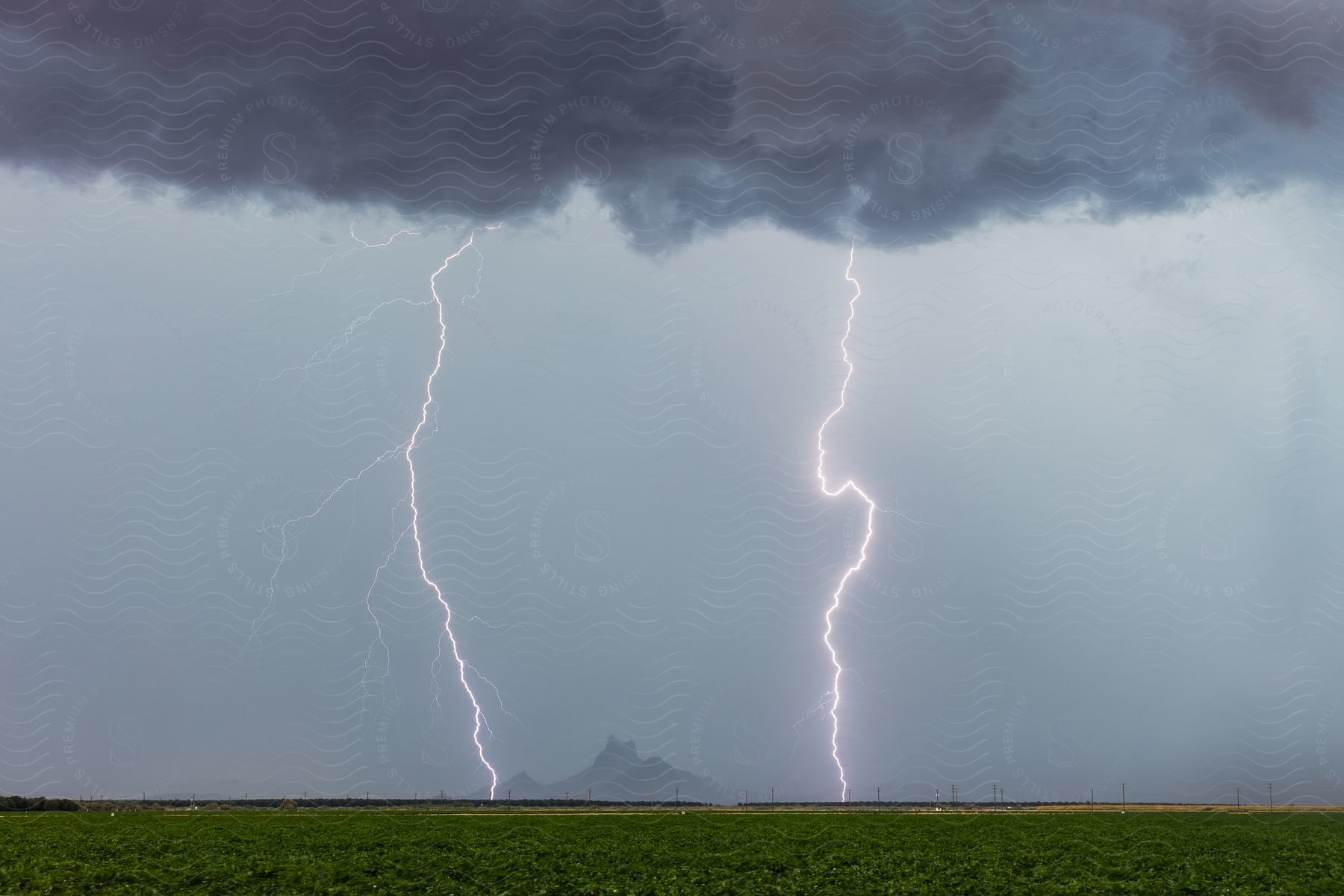 A thunderstorm with contrasting grasses and mountains