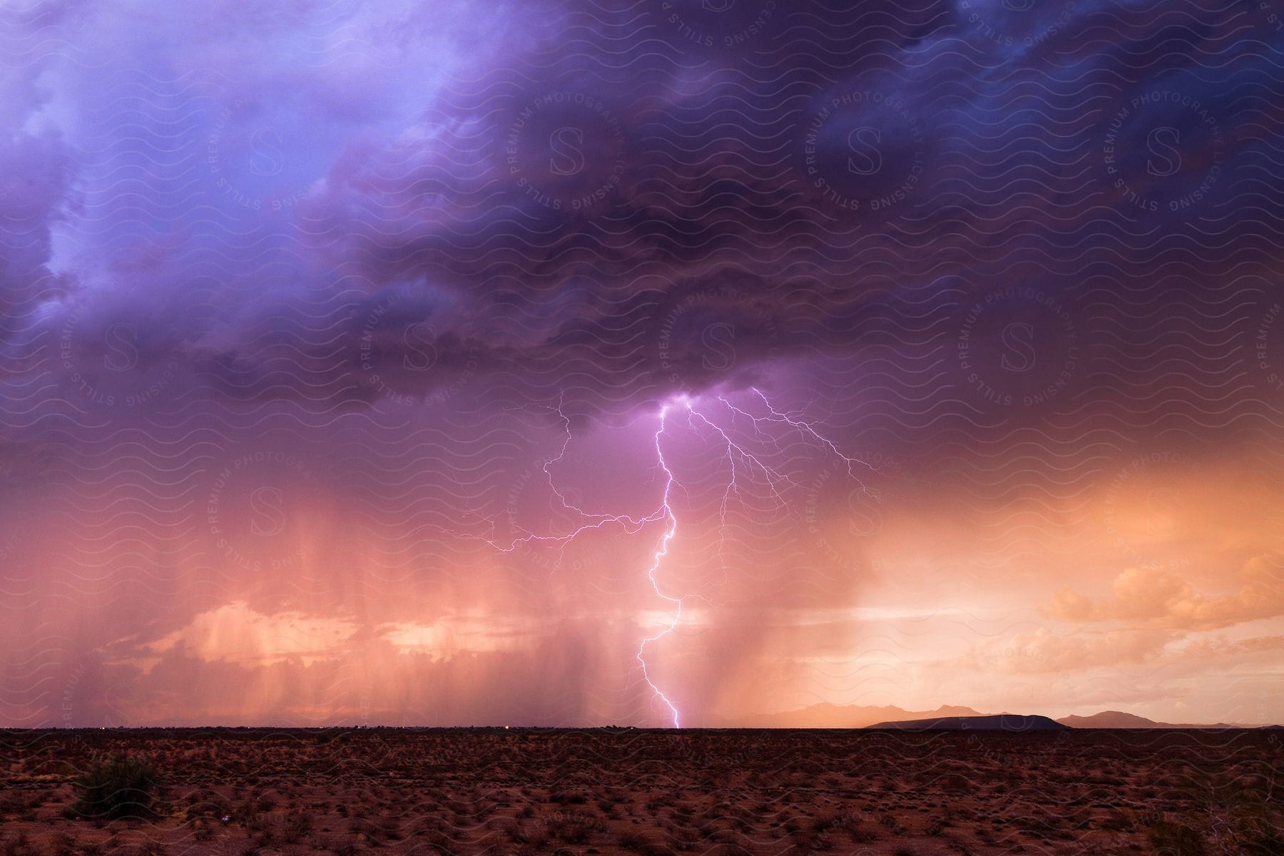 A stunning lightning bolt explodes from a thunderstorm during a beautiful sunset