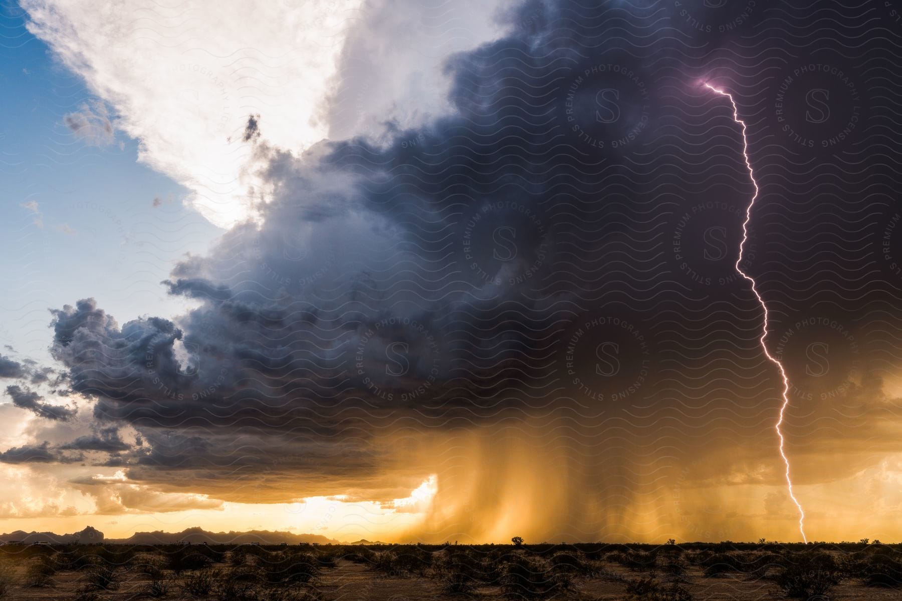 Thunderstorm with lightning striking a deserted land and rain falling from black clouds