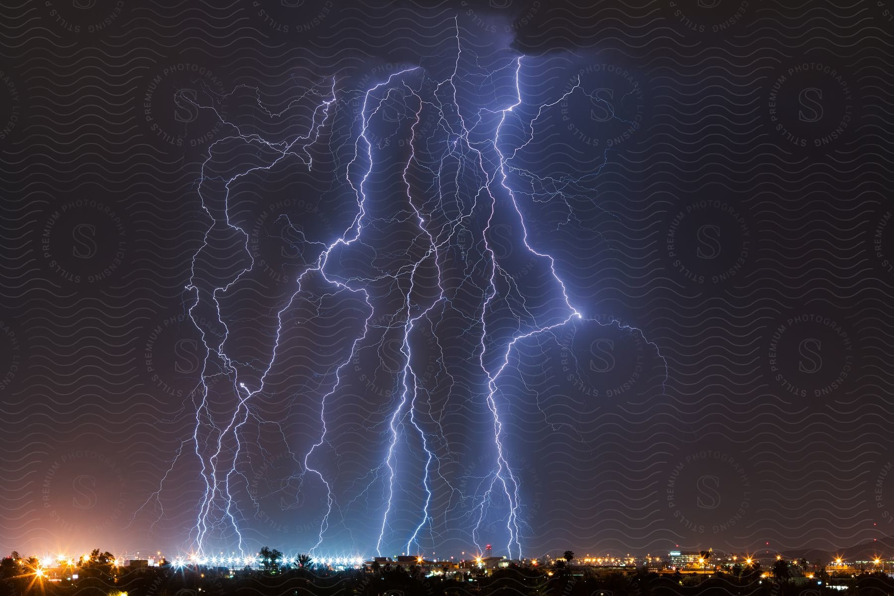 Thunderstorm above a city skyline at night time