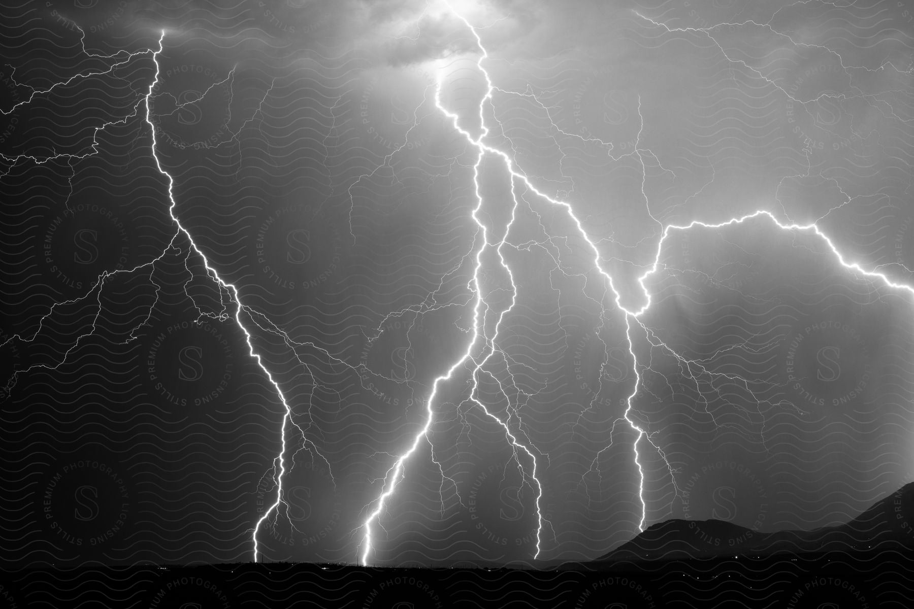 A stormy landscape with lightning in the sky