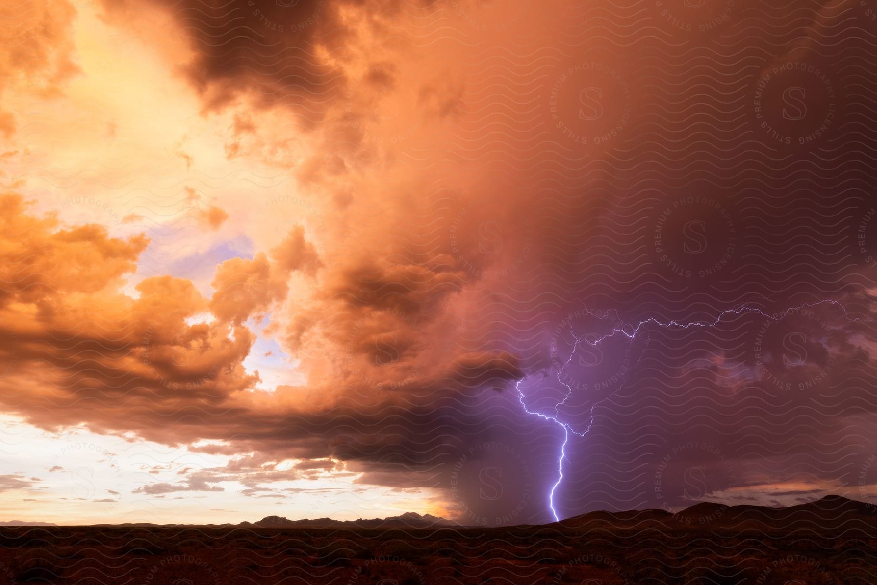 A blue lightning bolt strikes the desert hills at dusk in arizona