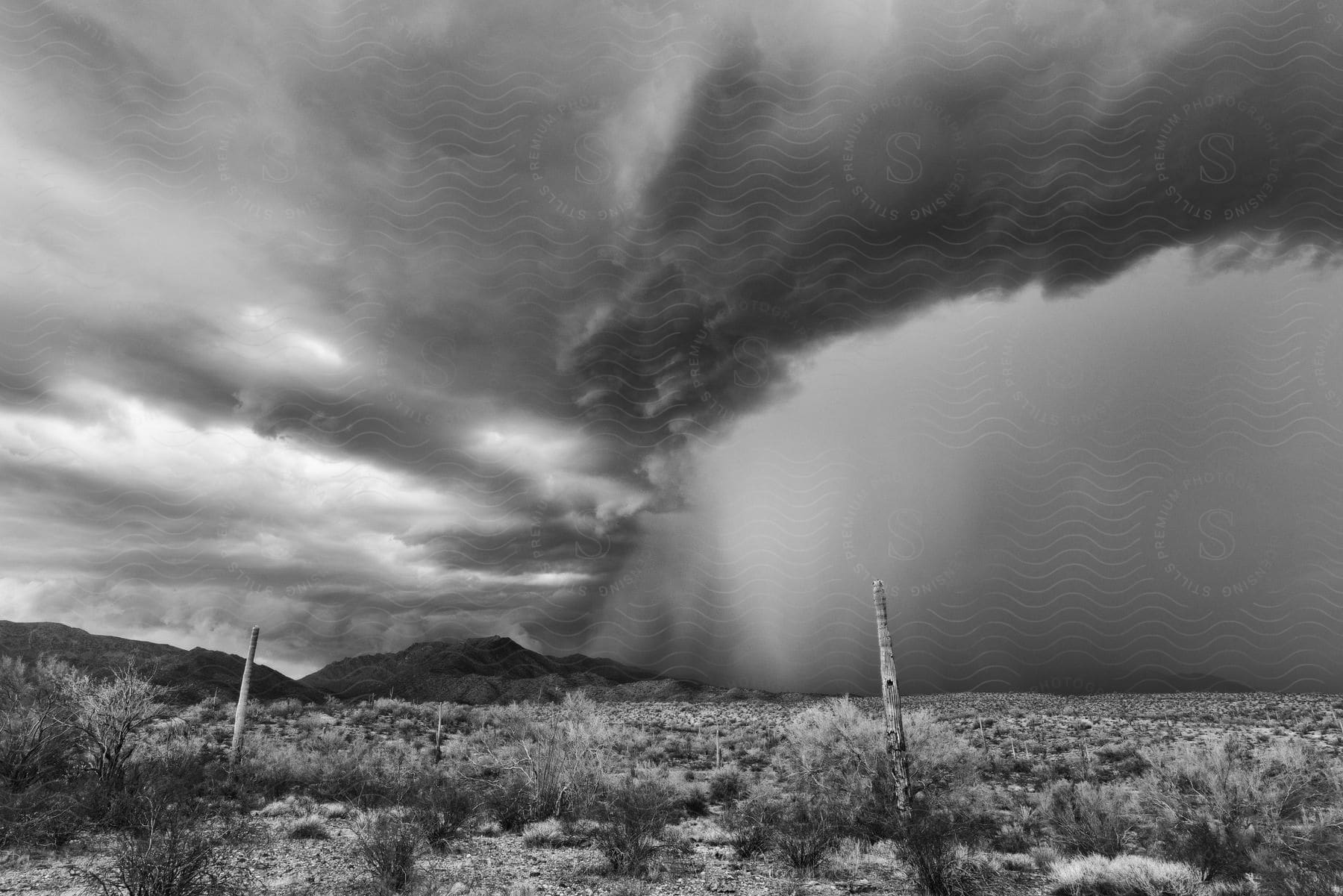 A stormy landscape with dark clouds and a body of water