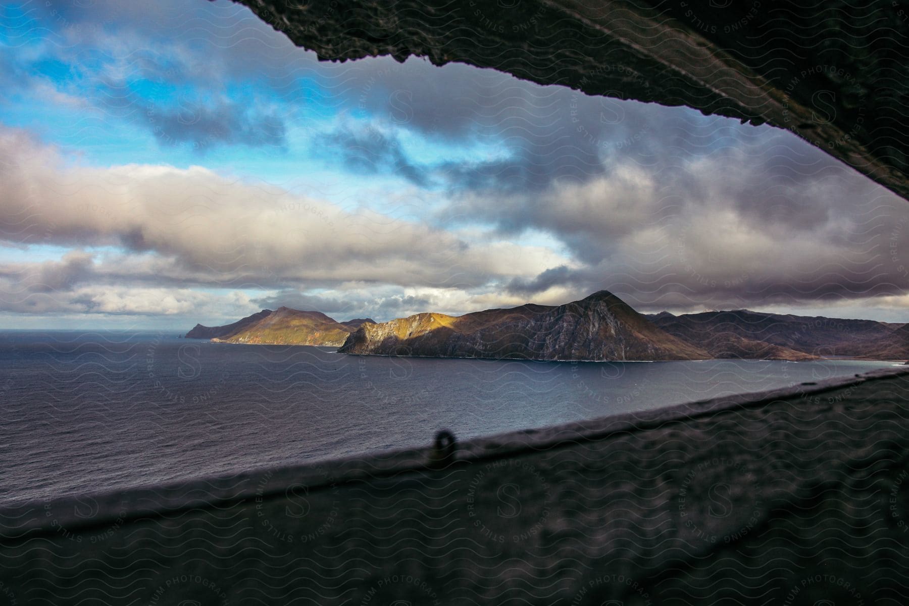 Sea with mountains in the background seen through a small window