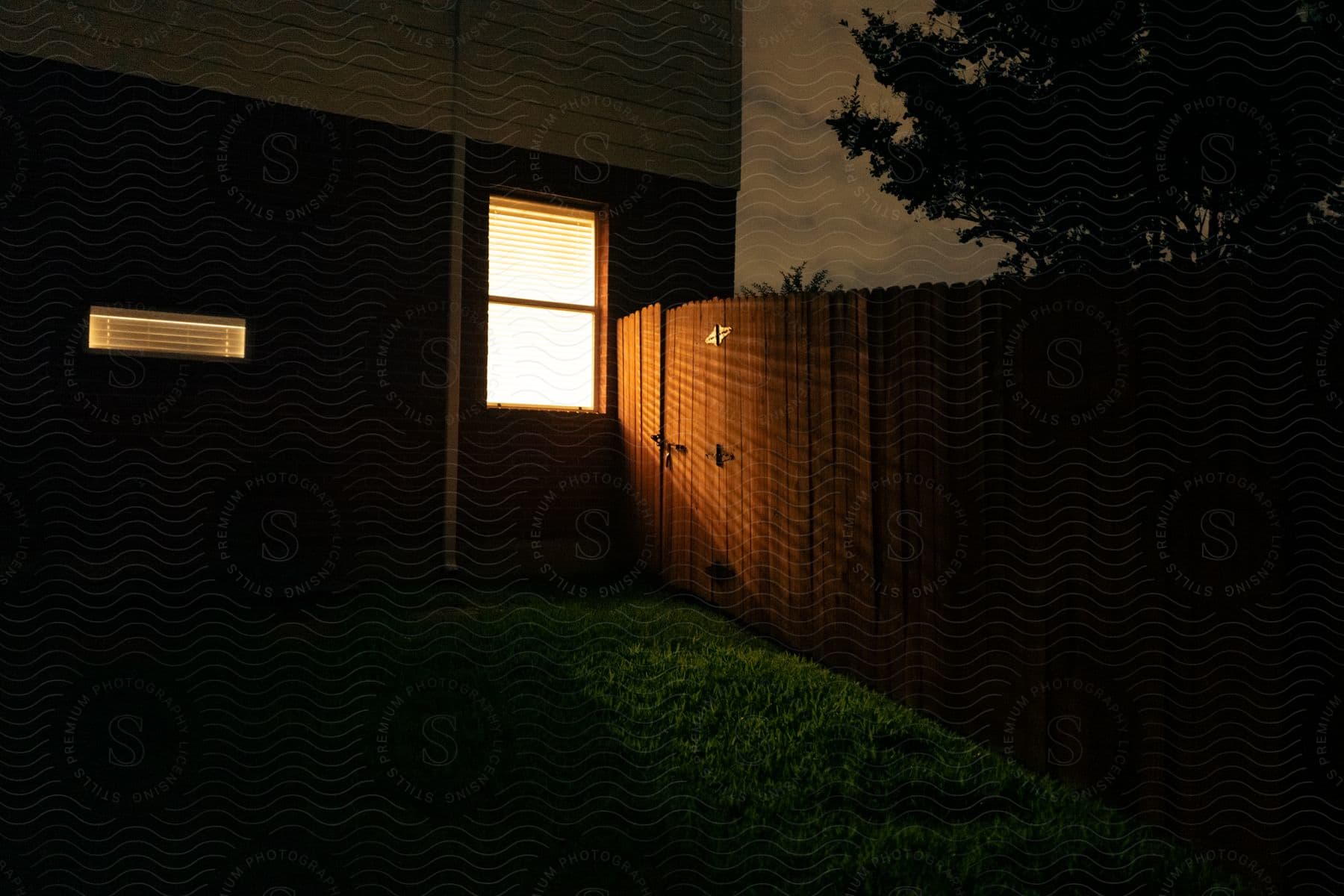 A wooden fence surrounds the backyard of a house