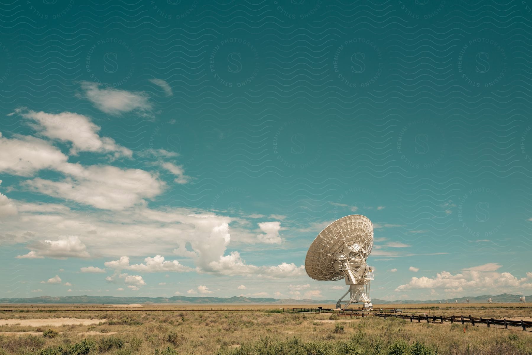 A satellite dish sits on plains covered in scrub brush