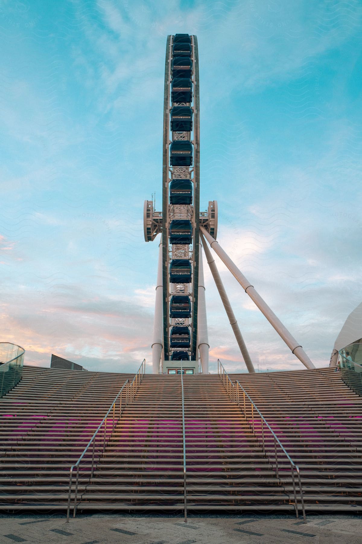 A large staircase leading to a white and blue ferris wheel