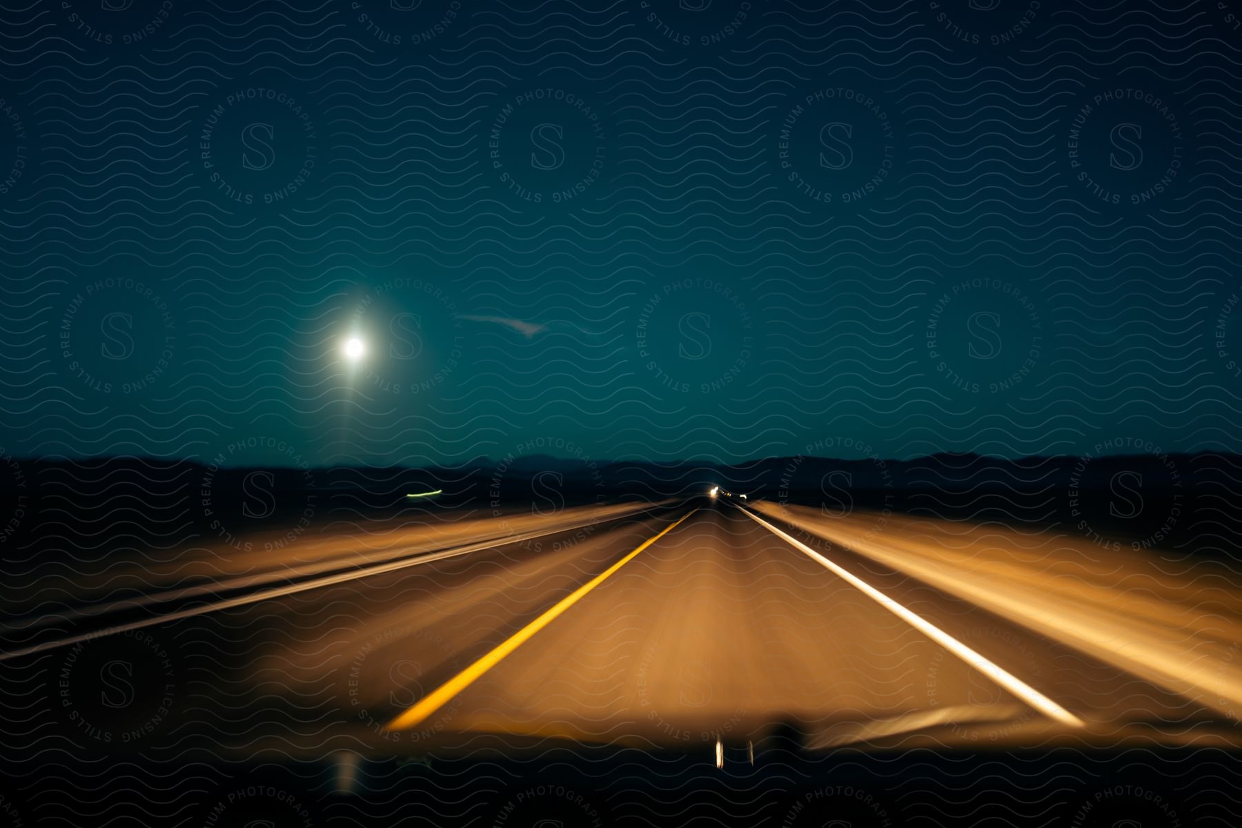 A car driving on a highway at night