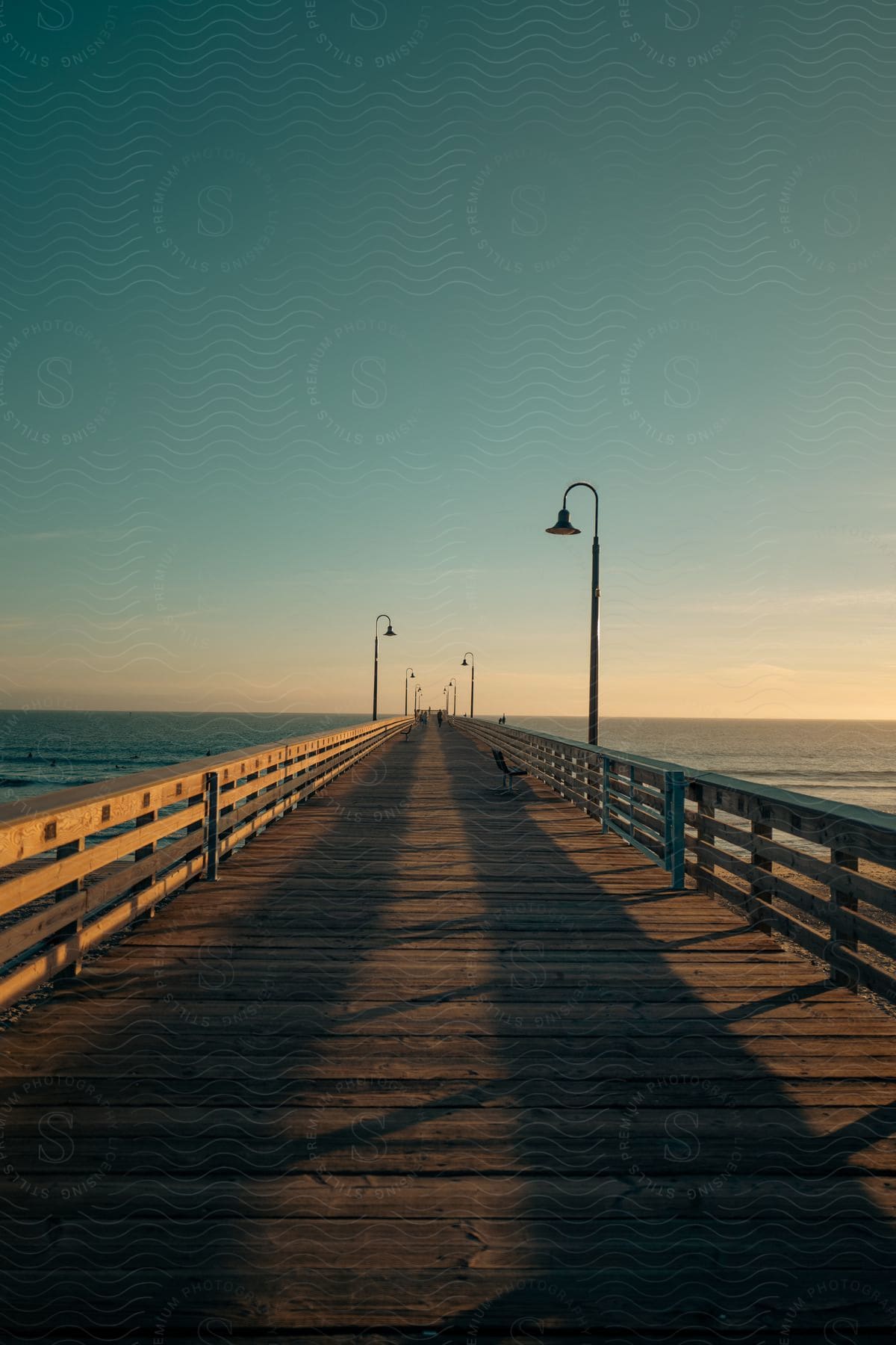 A wooden bridge at dusk with a waterfront view