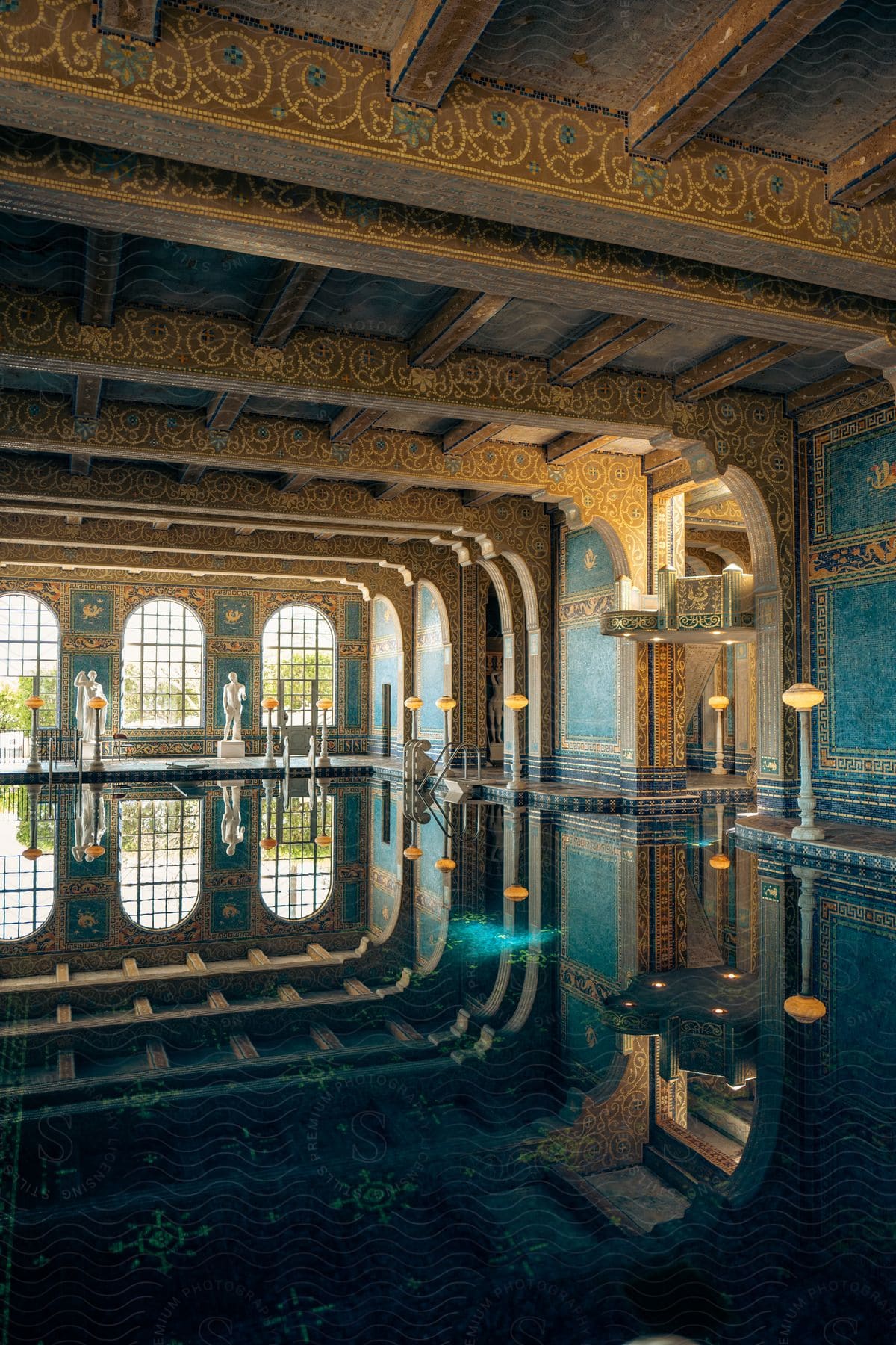 Ornately decorated interior of a building with yellow and teal patterns reflecting in a pool