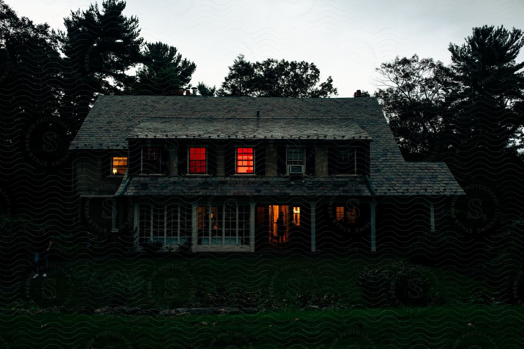 A house with windows surrounded by trees and grass